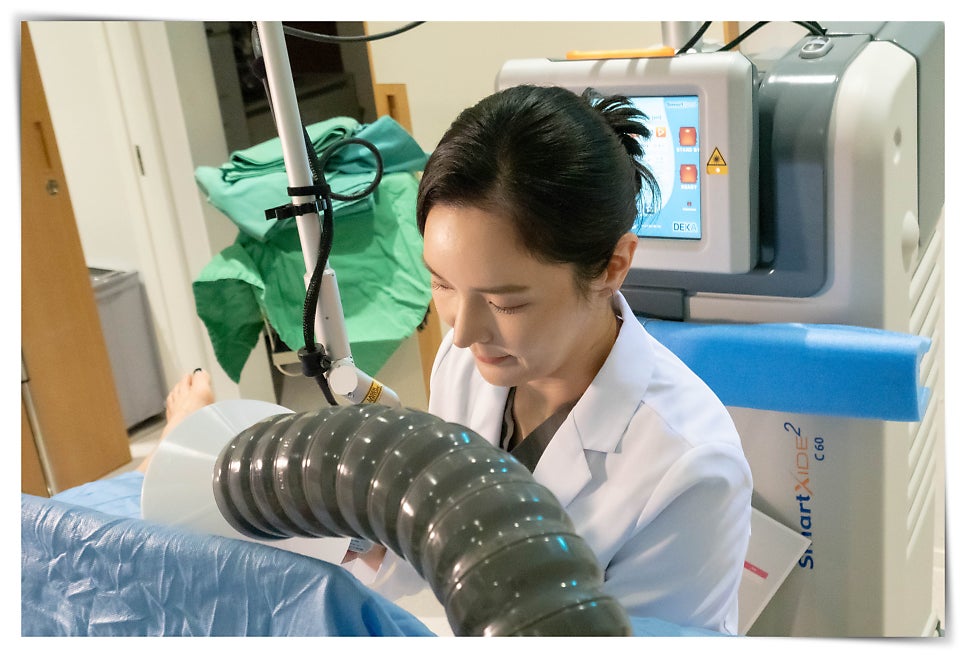 흰 가운을 입은 의료진이 'SmartXide2 C60'(DEKA) CO2 레이저 장비의 관절형 암과 발화구를
